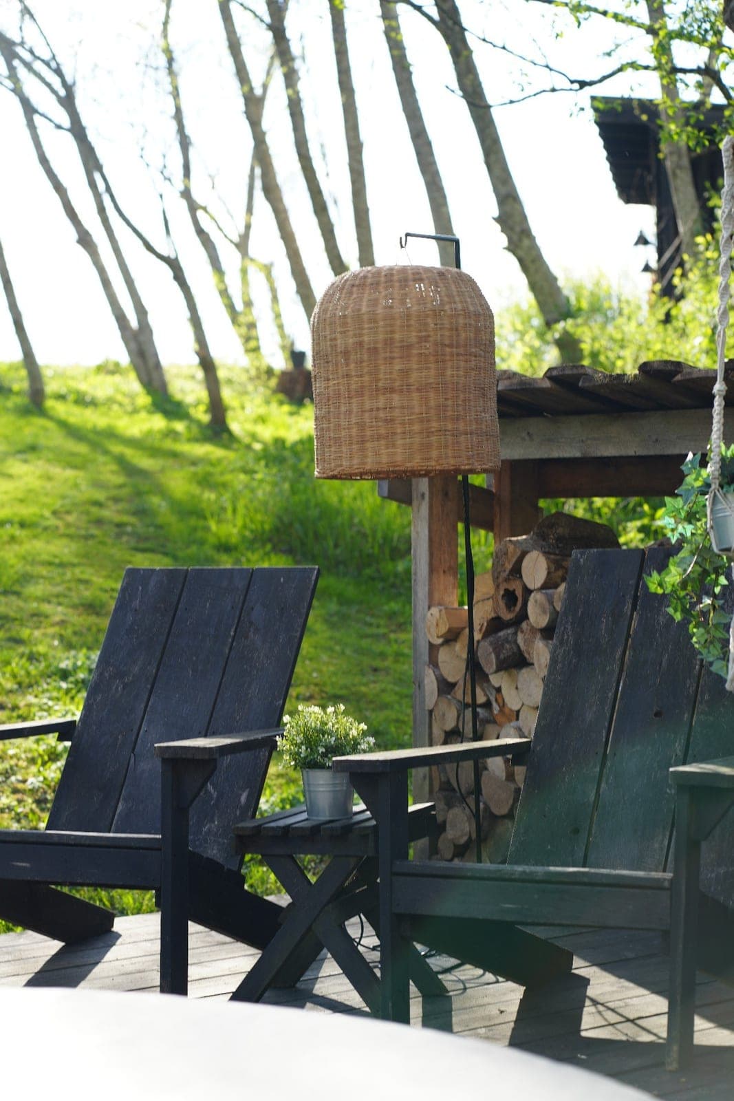 Custom woven floor lamp on a terrace between wooden chairs