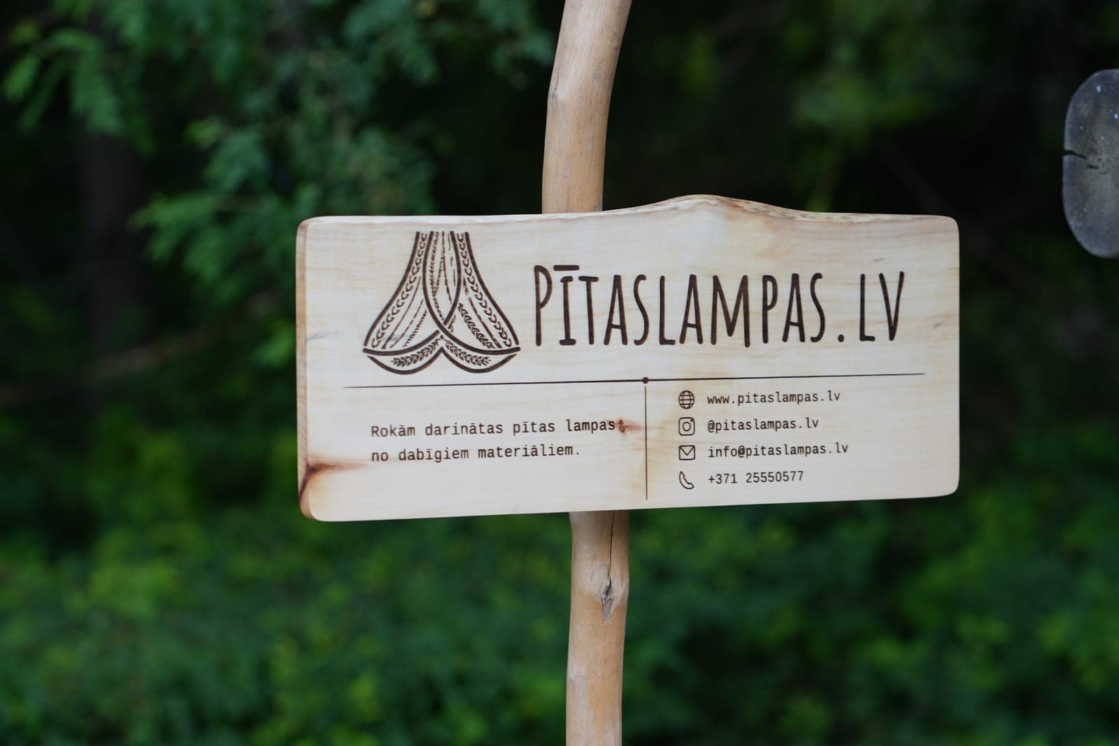 PītasLampas.lv wooden sign with burned-in logo: handwoven lamps from natural materials