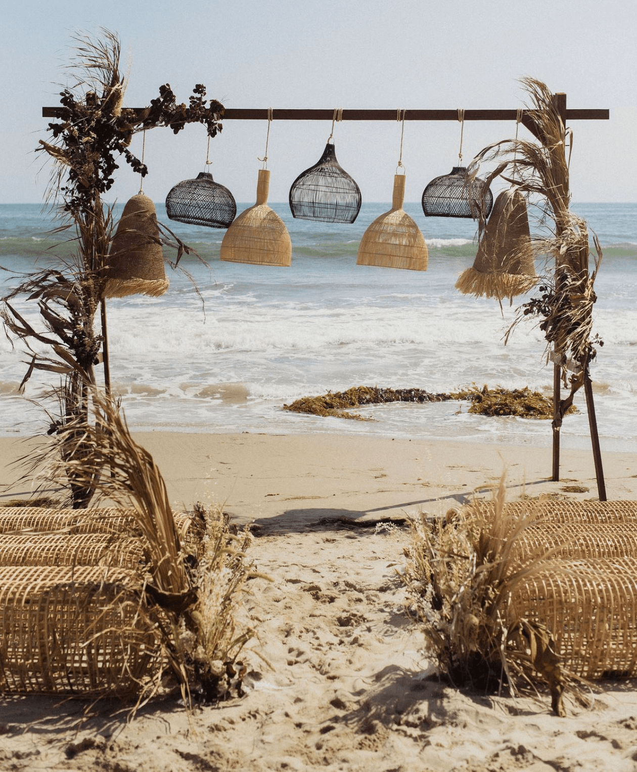 Decoration with woven lamps - seaside dinner setup with flowers.
